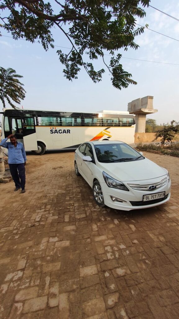 35 seater bus parked outside Travel Art Company office in Delhi, available for rent for group transportation.